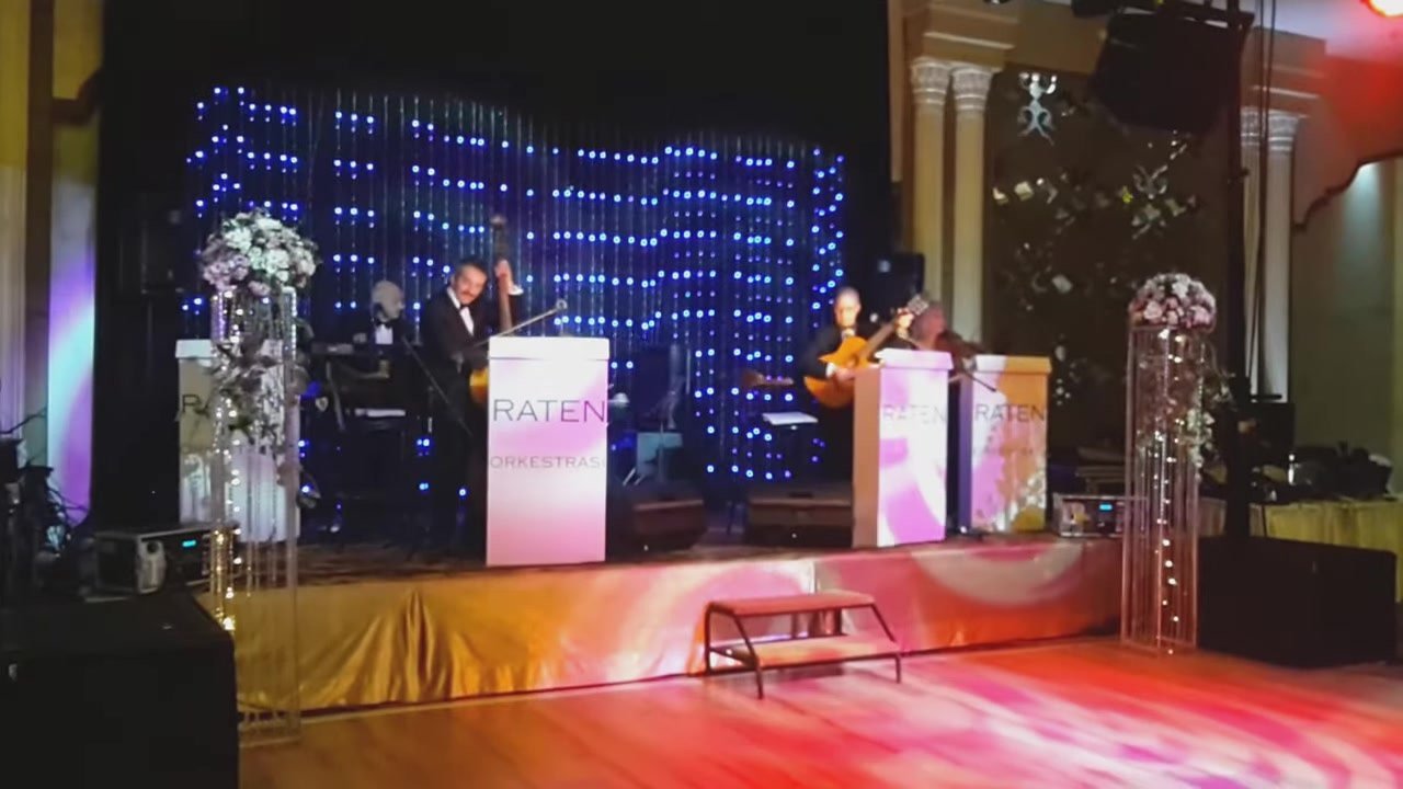 Raten kürsüleri ve LED perde önünde orkestra